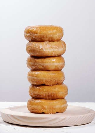mountain of donuts on a wooden round table on a white background