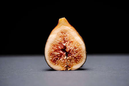 fig split in half on a gray surface on a black backgroundの写真素材
