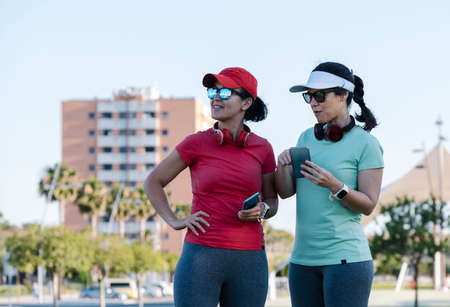 girls looking for location with mobile phone to exerciseの写真素材