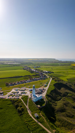 Aerial view of the lighthouse in the middle of a green fieldの写真素材