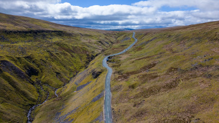 Aerial view of a winding road on the hillside in Scotlandの写真素材