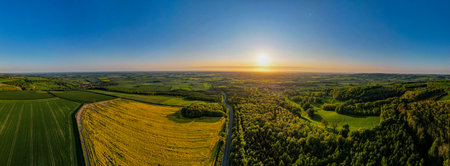 Aerial panorama of beautiful sunset over agricultural fields and meadowsの写真素材