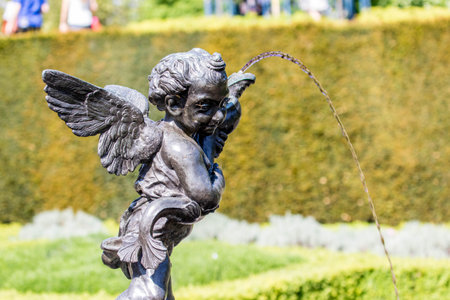 Statue of an angel with a fountain in the city park.の写真素材