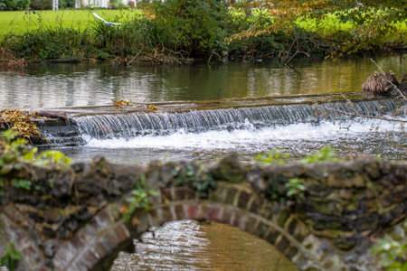 A view of a bridge over a stream in the countryside in autumnの写真素材