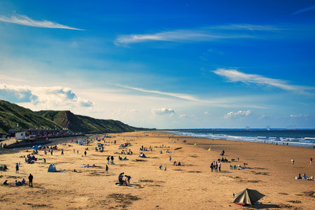 Beach with people and tents on a sunny day in spring.の写真素材