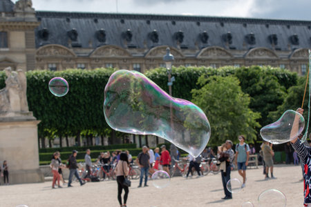 Unidentified people having fun with soap bubbles in the park.
