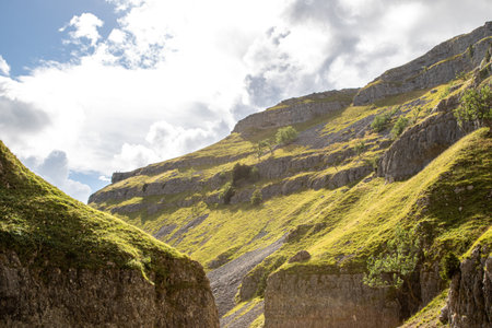 Mountain landscape with green meadow and blue sky with white cloudsの写真素材