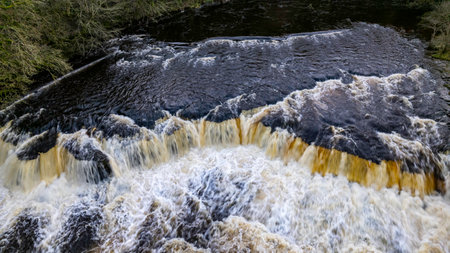 Waterfall on the river in the forest, close-up.