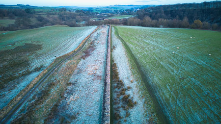 Aerial view of a railroad track running through a field in winterの写真素材