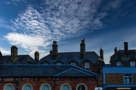 Dramatic sky over silhouette of traditional buildings with distinctive chimneys at dusk in Harrogate, England.の写真素材
