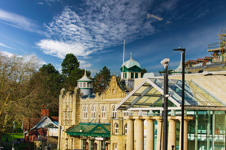 Sunny day over historic buildings with blue sky and fluffy clouds in Harrogate, England.