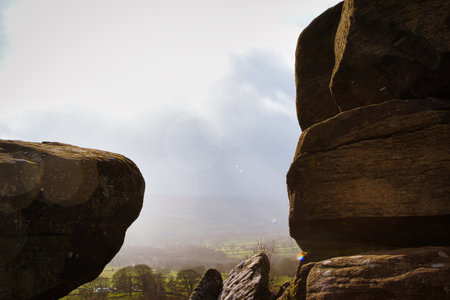 Scenic view of a landscape through rock formations under a cloudy sky at Brimham Rocks, in North Yorkshireの写真素材