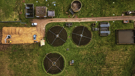 Aerial view of a wastewater treatment facility with circular tanks amidst green fields in North Yorkshire.の写真素材