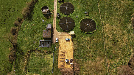 Aerial view of a wastewater treatment plant with circular tanks in a green field in North Yorkshire.の写真素材