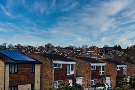 Suburban landscape with rows of British houses, featuring solar panels on roofs under a dynamic blue sky with wispy clouds in Harrogate, North Yorkshire.の写真素材