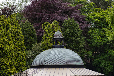 A domed roof structure surrounded by lush green and purple trees in a garden or park.の写真素材