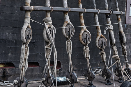 Close-up of rigging and ropes on an old sailing ship, showing detailed knots and wooden pulleys.の写真素材