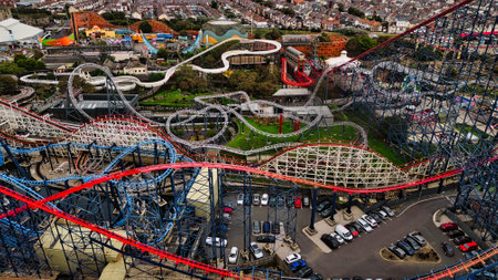 An aerial view of a vibrant amusement park featuring multiple roller coasters, winding tracks, and...