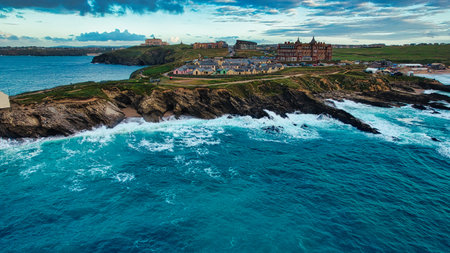 A scenic coastal view featuring rocky cliffs and a vibrant blue ocean. In the background, a charming...
