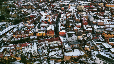Aerial view of a snow-covered residential area, predominantly featuring two-story brick houses with pitched roofs.  Narrow streets and small gardens are visible in Knaresborough, UK.の写真素材