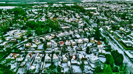 Aerial view of a snow-covered residential neighborhood.  Houses are predominantly single-family dwellings with pitched roofs.  Green spaces and roads are visible  in Harrogate, UK.の写真素材