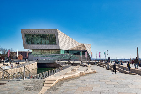 Wide shot of the Museum of Liverpool, UK, with people walking/sitting along the waterfront promenade...