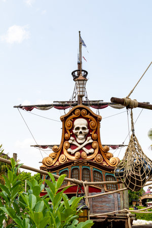 Close-up of a stylized pirate ship stern with skull and crossbones detail, rigging, and green...