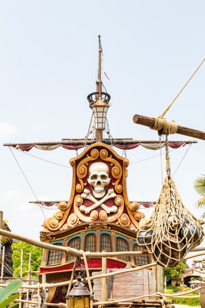 A partially visible pirate ship structure with skull and crossbones decor, ropes, mast, and netting against a bright sky  at Disneyland Paris.の写真素材