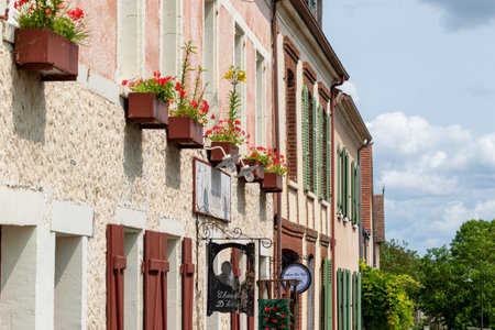 Facade of buildings with flower boxes and signs. Variety of textures and architectural styles in a European village setting in Giverny, France.の写真素材
