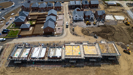 Aerial view of a residential construction site showing completed houses, houses under construction,...