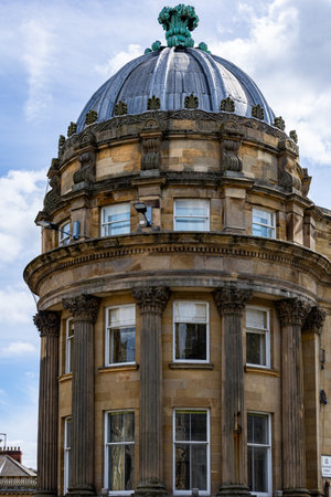 A curved stone building features a domed roof with a green finial and classical architectural elements including columns and ornate detailing  in Newcastle upon Tyne, UK.の写真素材
