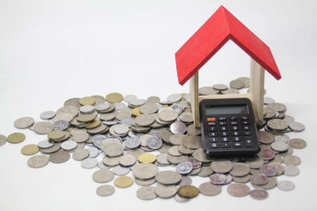 houses, calculators, books and coins scattered with white backgrounds. Selective focus.の写真素材