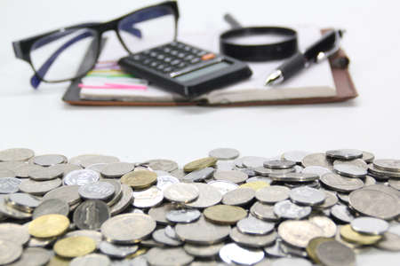 financial concept with notebook, pen, calculator, glasses and coins on the front. Selective focus.の写真素材