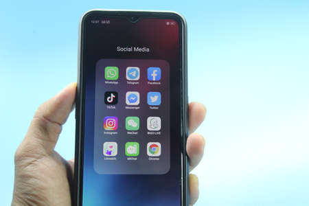 Malaysia, 14 July 2021 : hand holding a smartphone with a social media app on the screenのeditorial素材