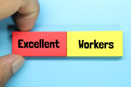 hand holding a colored block board with the words excellent workersの写真素材