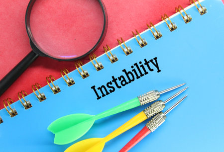 magnifying glass, arrows, notebook with the word instabilityの写真素材