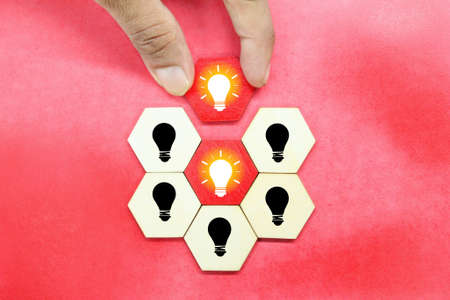 a wooden hexagon with a lighted bulb is taken and an unsuspecting bulb is leftの写真素材