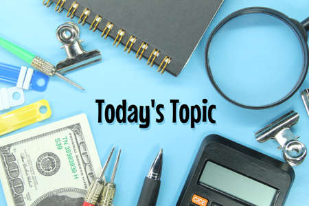 calculators, banknotes, pens, notebooks, clamps with today's topic words