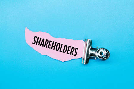iron clamps, torn paper with the word SHAREHOLDER