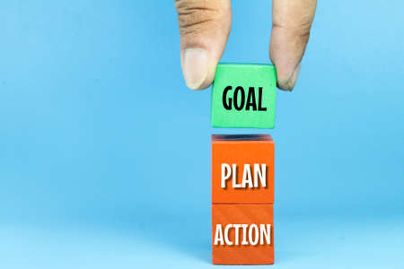 colored wooden cubes with the words goal, plan and action