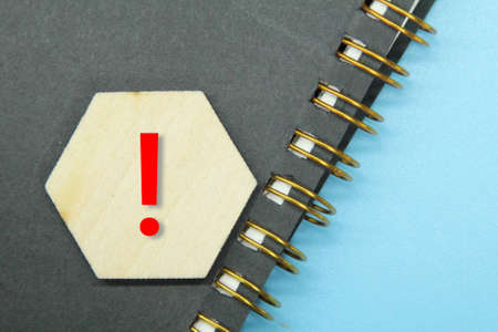 notebook, hexagon with exclamation mark and blue backgroundの写真素材