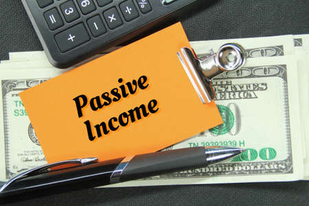 banknotes, pens, calculators, colored paper with the word Passive income