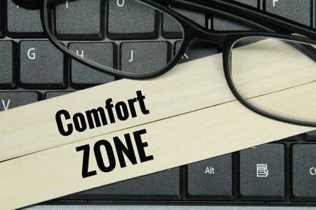 laptop keyboards, glasses, ice cream sticks with the word comfort zoneの写真素材
