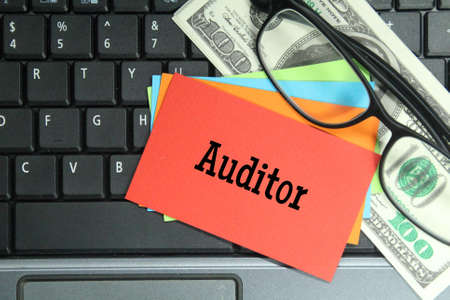 laptop keyboard, glasses, colored paper with the word auditorの写真素材