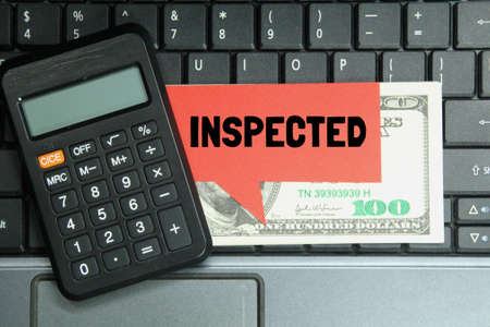 laptop keyboard, calculator, conversation box with the word inspectedの写真素材