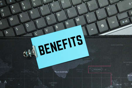laptop keyboard, colored paper with the word benefitsの写真素材