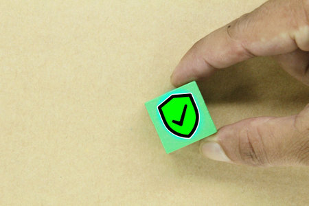 by holding a cube with a security icon. safety and security concept