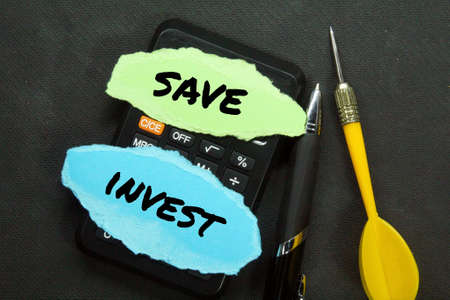 calculator, pen, arrow, torn paper with the words save or invest
