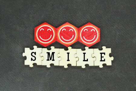 wooden puzzle and hexagon with smile icon the word smile