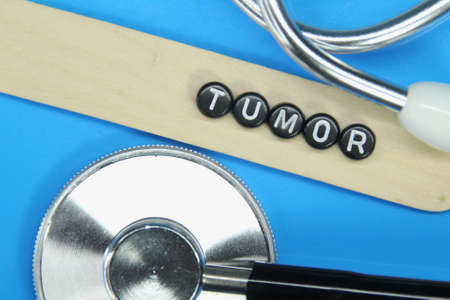 a blue wooden stethoscope with the word tumor on a small circleの写真素材